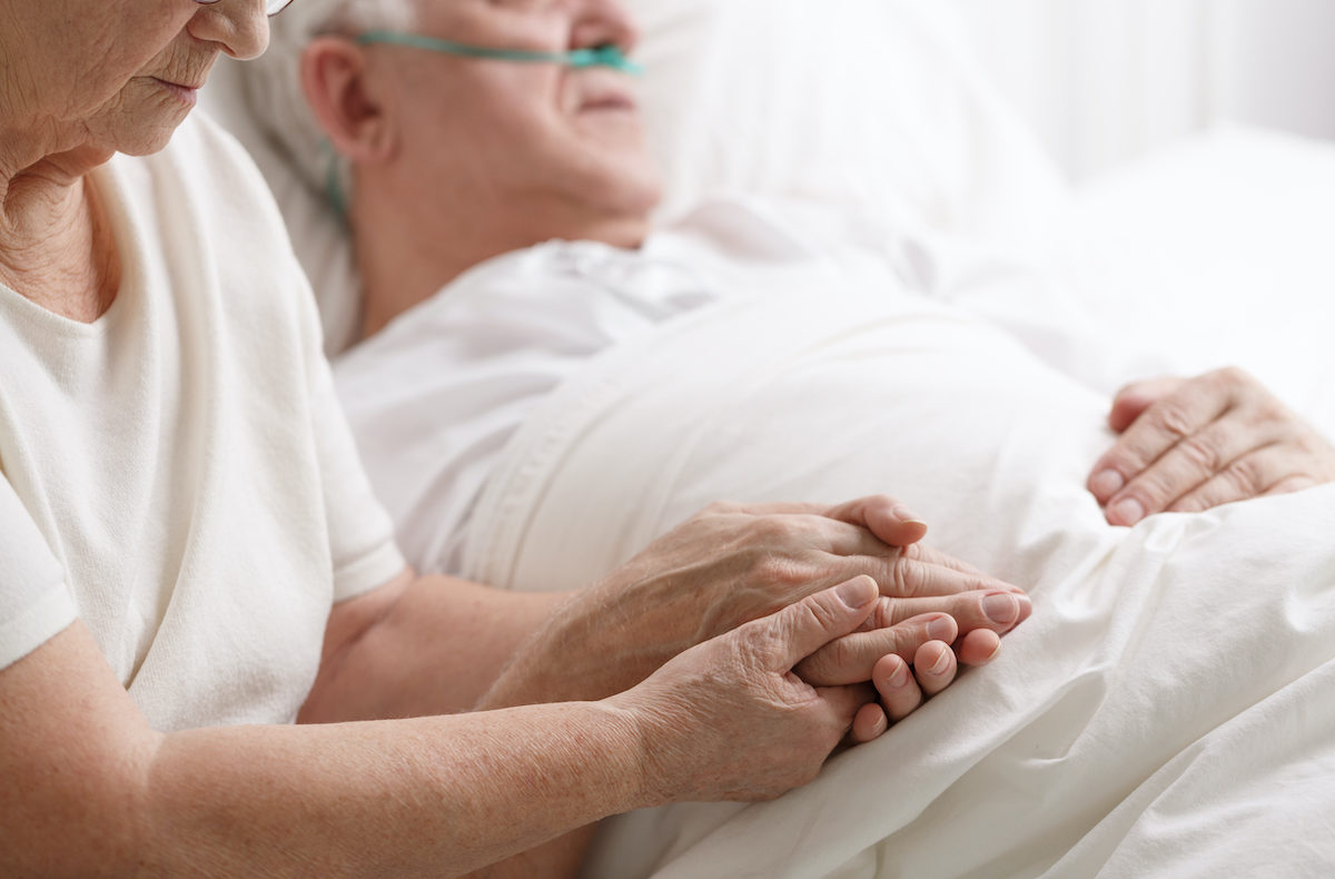 femme-qui-tient-la main-a-un-homme-malade